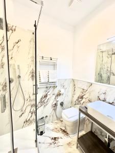 y baño con ducha, aseo y lavamanos. en AD Suites Nazionale en Roma
