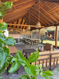 a patio with tables and chairs and a wooden pergola at Mama Yé in Lodero