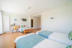 a hotel room with two beds and a desk at Centre Jean XXIII in Annecy