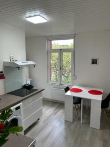 a room with a kitchen with a table and a window at Richelieu 2 chez Adrien in Saint-Quentin