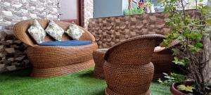 two wicker chairs with pillows on a patio at Tea corner Guest house in Darjeeling