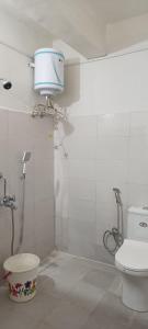 a bathroom with a toilet and a shower with a tank at Tea corner Guest house in Darjeeling