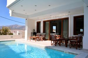 a villa with a swimming pool and a table and chairs at Villa Ariadne in Athens