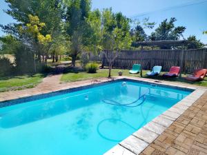 a swimming pool with two chairs and a fence at Fairfield Cottages in Ceres