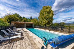 uma piscina com espreguiçadeiras ao lado de uma casa em Villa de 6 chambres avec piscine privee jardin clos et wifi a Saignon em Saignon
