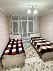 TürkistanにあるЭлитная новая квартира в Туркестане 2の窓付きの客室で、ベッド2台が備わります。