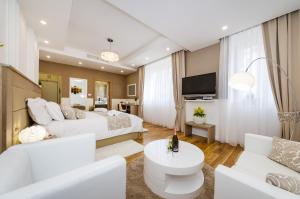 a hotel room with two beds and a couch at Peninsula Luxury Suite in Zadar