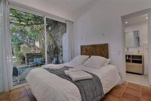 a bedroom with a bed and a large window at Villa des Fontenelles in La Croix-Valmer +33 photos