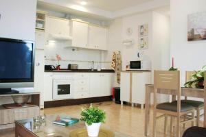 a kitchen with white cabinets and a table and a tv at 2 bedrooms appartement with wifi at San Cristobal de La Laguna in Las Lagunas
