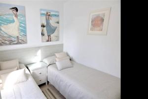 a bedroom with two beds and paintings on the wall at 2 bedrooms appartement with wifi at San Cristobal de La Laguna in Las Lagunas