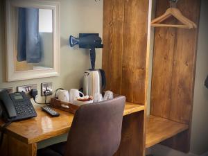 a wooden desk with a phone and a telephone at Tyr Winch in Cardiff