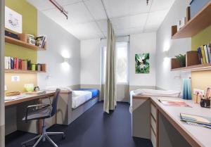 a bedroom with a bed and a desk and a desk at Giovenale Milan Navigli - Modern rooms and open spaces in the heart of the city in Milan