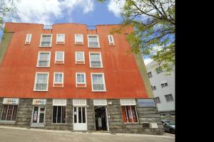 a large orange building with white windows on a street at 2 bedrooms appartement with wifi at San Cristobal de La Laguna in Las Lagunas