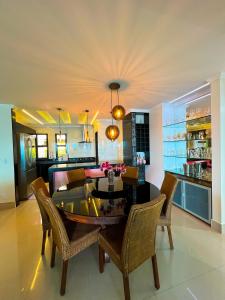 uma sala de jantar com uma mesa e algumas cadeiras em Apartamento LUXO no Porto Real Resort ao lado da praia em Mangaratiba