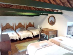 Cette chambre comprend 4 lits, une table et un miroir. dans l'établissement 7 bedrooms villa with private pool furnished garden and wifi at Malaga, à Malaga