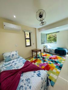 um quarto com uma cama e um tapete colorido em Apartamento LUXO no Porto Real Resort ao lado da praia em Mangaratiba