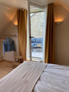 Schlafzimmer mit einem Bett und einer Glasschiebetür in der Unterkunft BeauVenue in Veurne