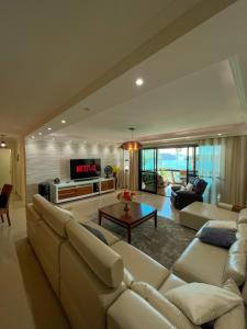 een grote woonkamer met een bank en een tv bij Apartamento LUXO no Porto Real Resort ao lado da praia in Mangaratiba