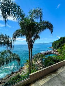 una palmera frente al océano en Apartamento LUXO no Porto Real Resort ao lado da praia, en Mangaratiba