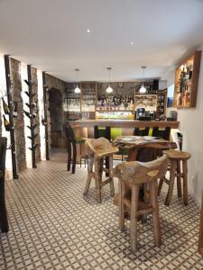 um restaurante com mesas e cadeiras de madeira e um bar em Hôtel Casale Olmia 