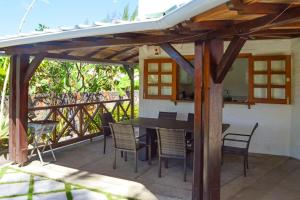 a patio with a table and chairs under a pergola at 4 bedrooms villa with private pool enclosed garden and wifi at Mahebourg 1 km away from the beach in Mahébourg