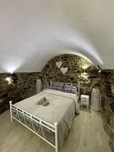 a bedroom with a bed in a stone wall at Plavoukos'house in Kótronas