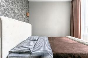 um quarto com uma cama com uma cabeceira branca e uma janela em 0157 Сучасні нові апартаменти ЖК Щасливий em Kiev