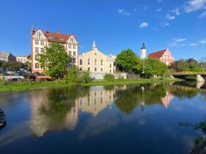 Blick auf einen Fluss mit Gebäuden und einer Brücke in der Unterkunft Red Bike Old Town in Oppeln