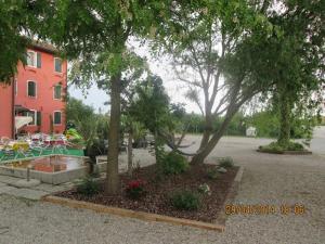 un parc avec des arbres et des fleurs devant un bâtiment dans l'établissement Quadrifoglio Relax, à San Donà di Piave