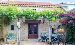 an old stone house with a table and chairs at Charming House in Añora with Garden in Anora