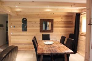 オトリュスにあるAppartement de 3 chambres avec jardin et wifi a Hauteluce a 2 km des pistesのダイニングルーム(木製テーブル、椅子付)