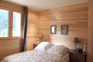 a bedroom with wooden walls and a bed and a window at Appartement de 3 chambres avec jardin et wifi a Hauteluce a 2 km des pistes in Hauteluce