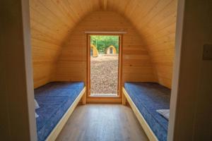 a room with two beds in a room with a window at Ghyll Head Hive Pod Village & Accessible Bungalow in Winster