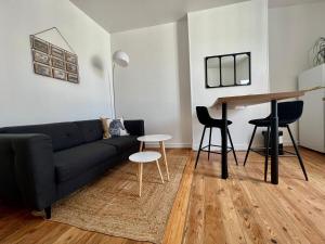 a living room with a couch and a table at Au coeur de ville in Laval