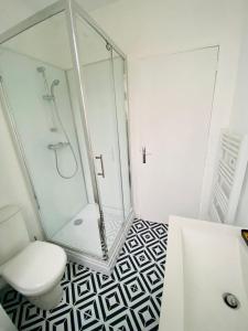 a bathroom with a glass shower and a toilet at Au coeur de ville in Laval +4 photos