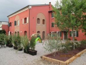 un edificio rojo con un parque infantil delante de él en Quadrifoglio Relax, en San Donà di Piave