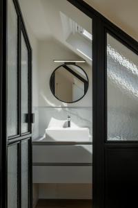 y baño con lavabo y espejo. en The Rose Flats en Bruselas