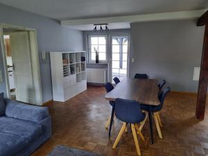 uma sala de estar com uma mesa de madeira e cadeiras azuis em Wohnung in Bad Lippspringe em Bad Lippspringe