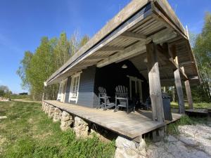 a porch of a house with chairs on it at Pelėdų Namelis in Šlaveitai