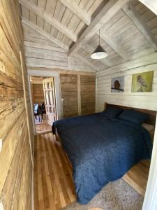 a bedroom with a bed in a wooden cabin at Pelėdų Namelis in Šlaveitai