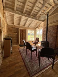 a living room with a table and a fireplace at Pelėdų Namelis in Šlaveitai