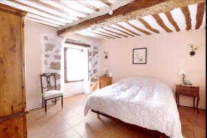 Un dormitorio con una cama blanca y una silla. en Spacious House in Llano de Bureba with Fireplace & Mountain View, en Llano de Bureba