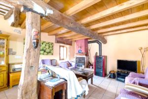 Una sala de estar con techos de madera y sillas moradas. en Spacious House in Llano de Bureba with Fireplace & Mountain View, en Llano de Bureba