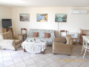 een woonkamer met een bank, 2 stoelen en een tafel bij 2 bedrooms appartement with furnished terrace at Taormina 3 km away from the beach in Taormina