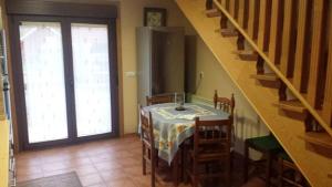 una cocina con una mesa con sillas y una escalera en 3 bedrooms house with private pool jacuzzi and enclosed garden at Pontevedra en Rífrío