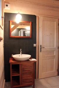 a bathroom with a sink and a mirror and a door at Appartement de 5 chambres avec jardin et wifi a Hauteluce a 2 km des pistes in Hauteluce