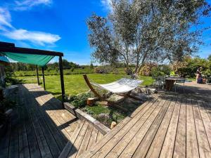 eine Hängematte auf einer Terrasse mit einem Tisch und einem Feld in der Unterkunft grande villa, piscine chauffée, proche Bordeaux in Lignan-de-Bordeaux