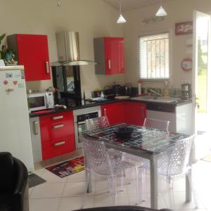 a kitchen with red cabinets and a table and chairs at Petit coin de paradis avec jardin clôturé à Auch in Auch