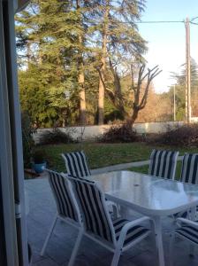 three chairs and a table on a patio at Petit coin de paradis avec jardin clôturé à Auch in Auch