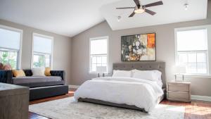 a bedroom with a bed and a couch and windows at Casa Swinton in Delray Beach